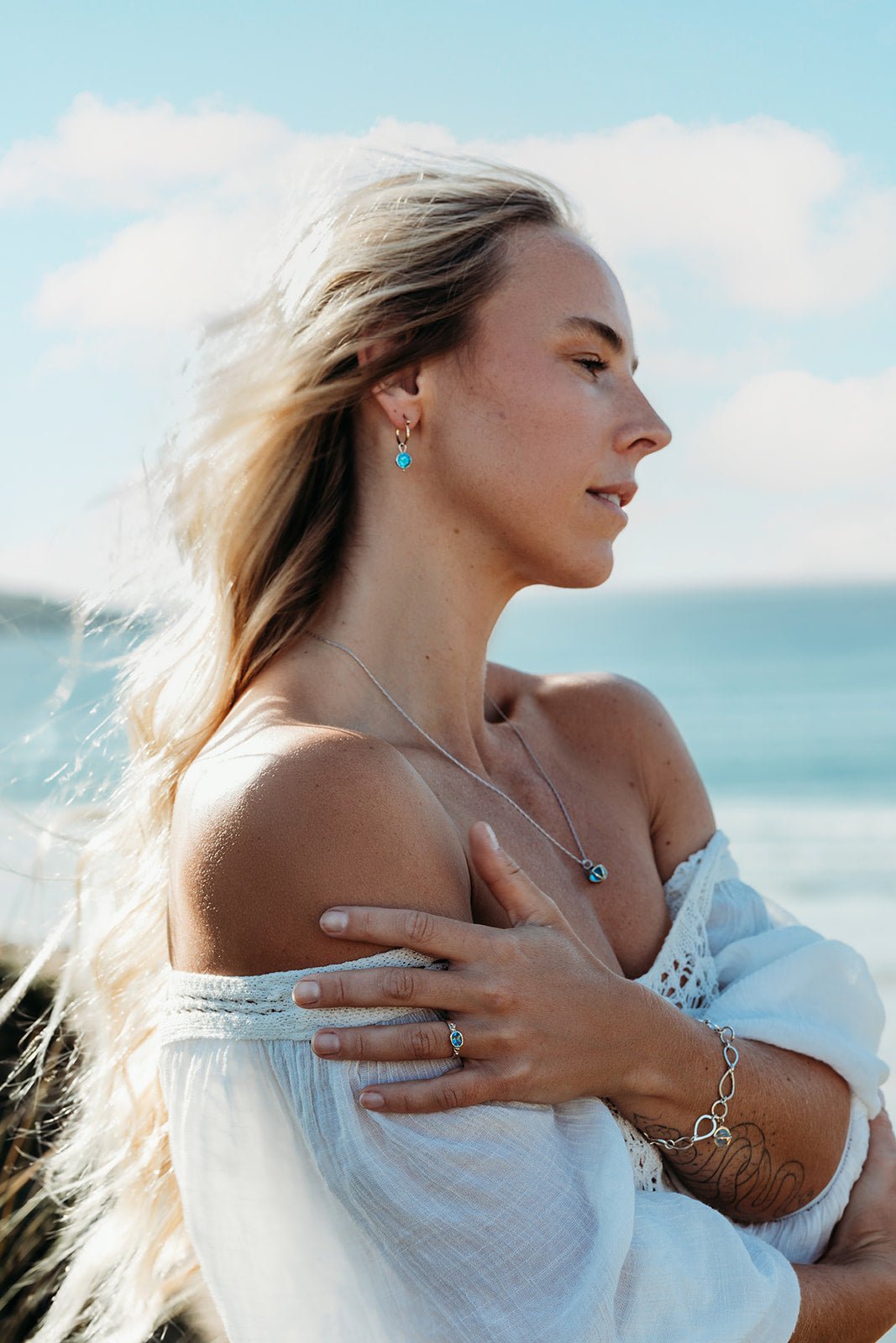 Model with long blonde hair wearing Drop of the Ocean Necklace - Fairtrade 9 Carat White Gold & Swiss Blue Topaz Sphere Necklace by Booblinka Jewellery