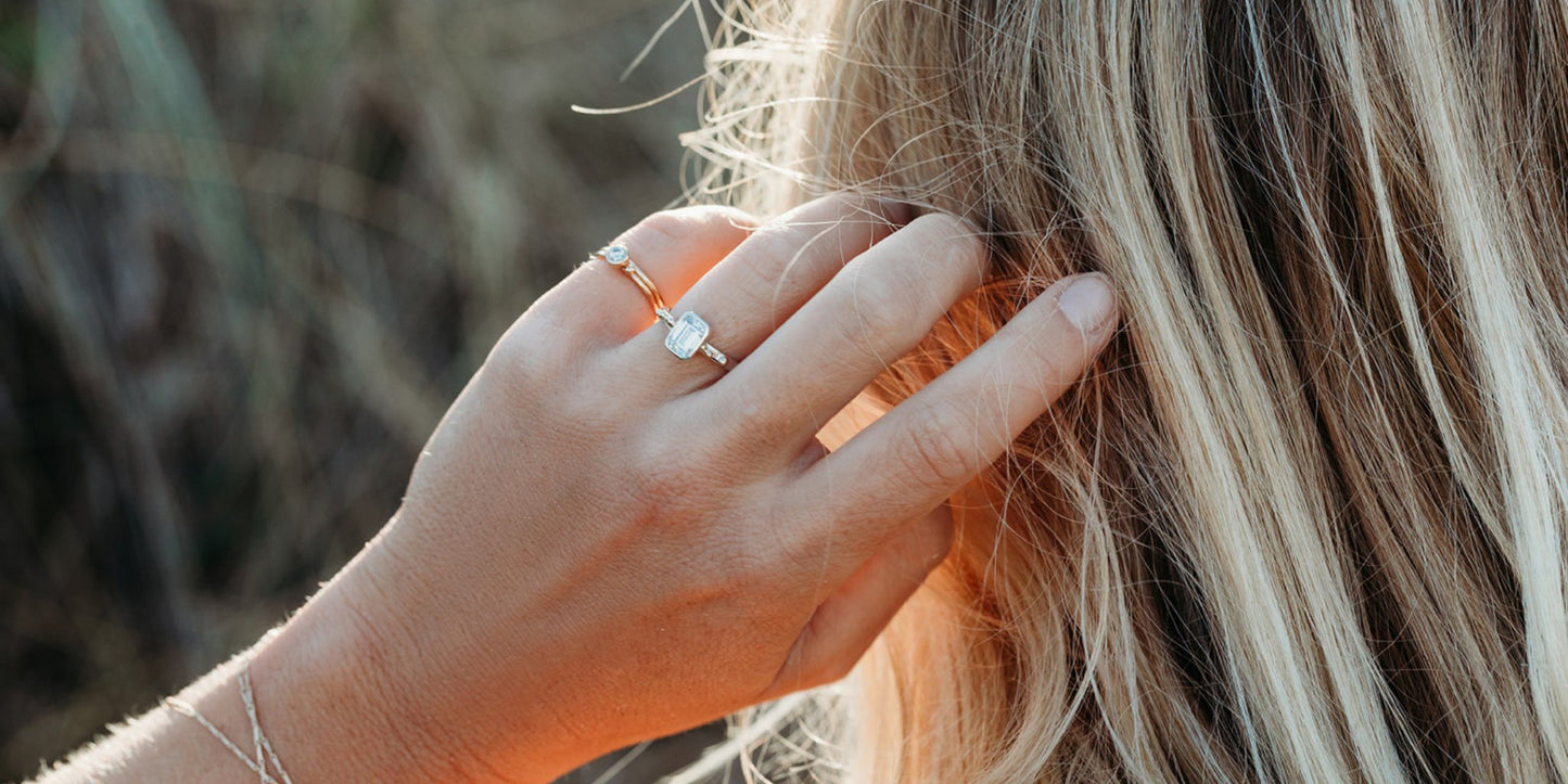 Emerald-Cut Moissanite and Gold Accent Ring  from DEI Collection on hand running through blond hair by Booblinka jewellery