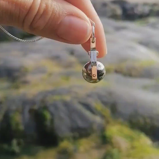 Video of the spinning moon necklace in sterling silver with a blue gemstone, showcasing its unique design as seen in 'Playing Nicely' by Booblinka Jewellery 