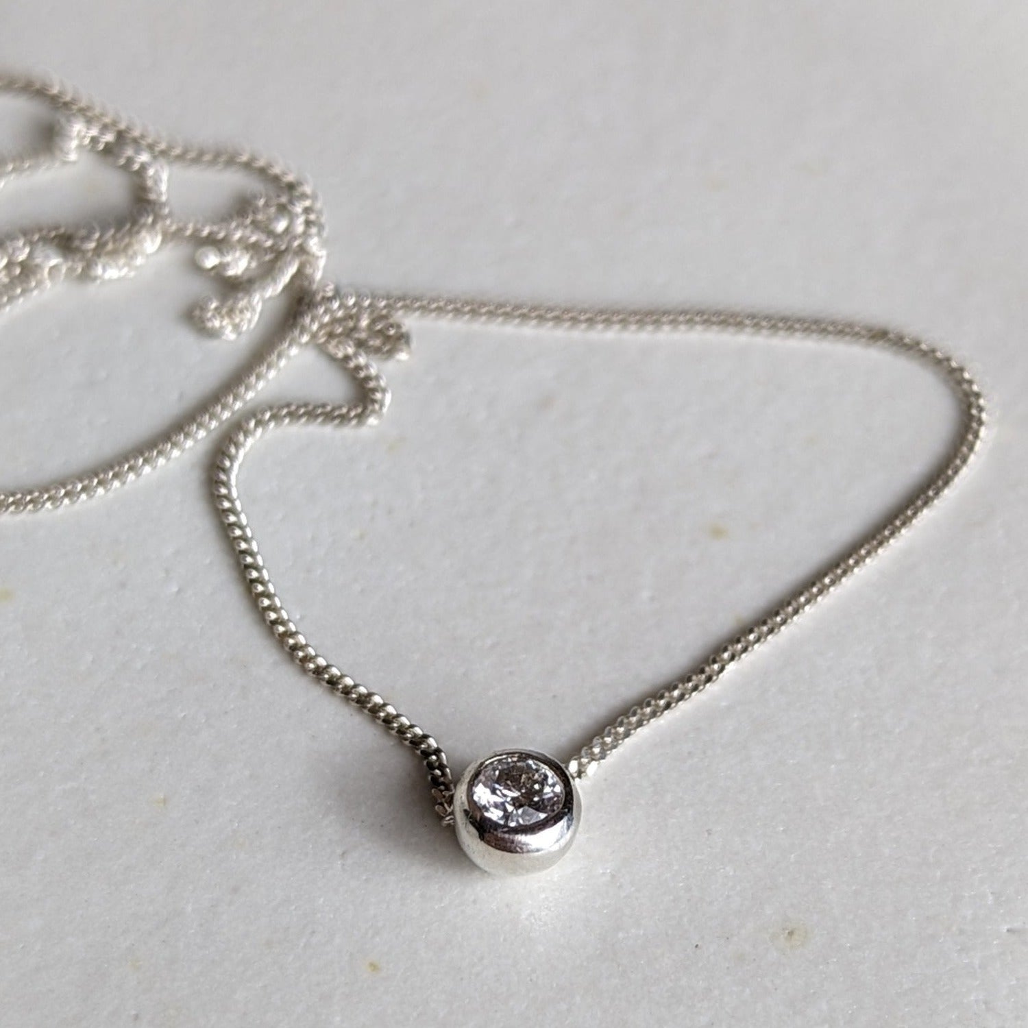 Minimalist silver DEI necklace with moissanite on white background - Booblinka Jewellery